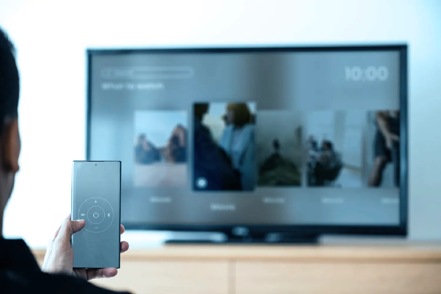 man-changing-tv-channel-by-his-smartphone-smart-home-neiroom-1